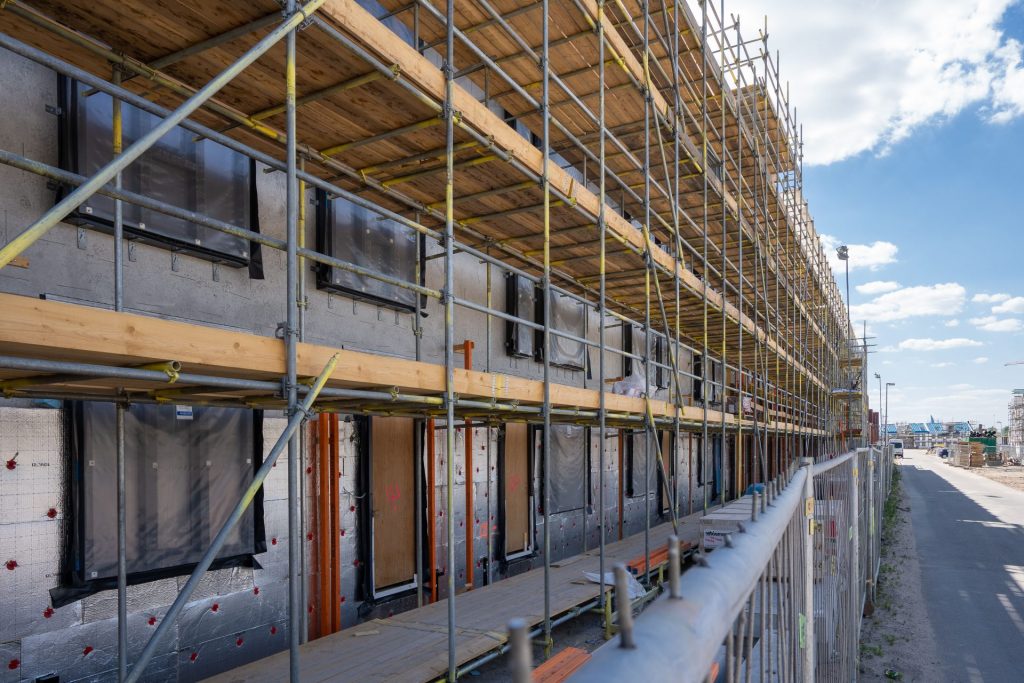 Scaffolding at a city construction site with clear blue skies.